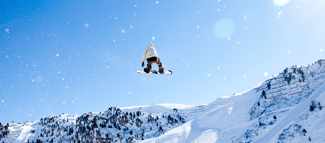 A snowboarder souring high in the air.